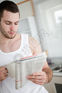 一名男子在看新闻时喝橙汁的肖像图片
