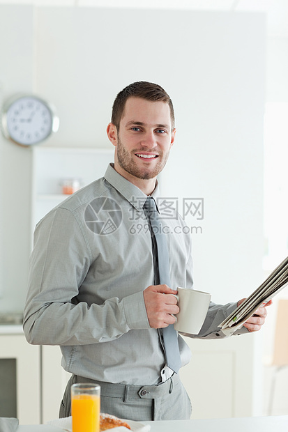 一位微笑着的商务人士在读新闻的同时阅读新闻的肖像图片