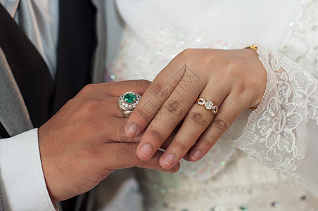 握着钻石戒指的结婚情侣手背景图片