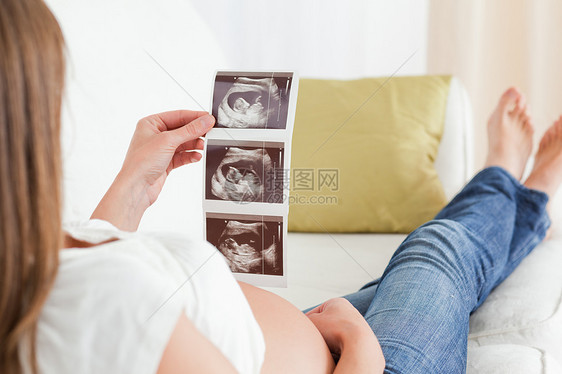 美丽的孕妇在看一个传声术时图片
