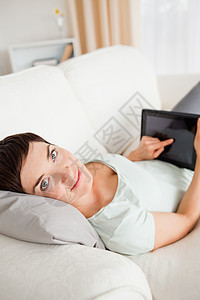 使用平板电脑的妇女的肖像头发沙发屏幕技术软垫女性黑发展示女孩快乐图片