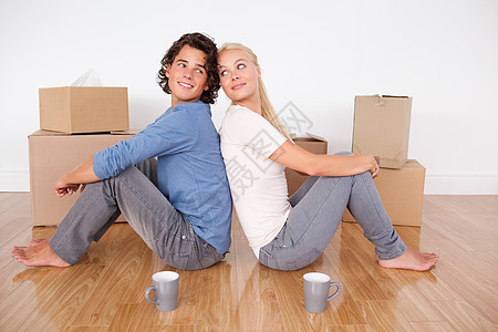 坐在地板上可爱的一对情侣女士妻子丈夫女性开箱咖啡休息恋人公寓建筑图片
