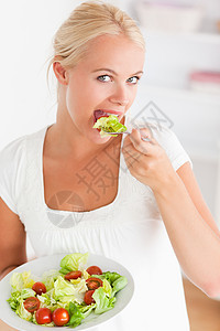 一个女人吃沙拉的肖像厨房女性午餐金发女郎食物重量女士金发蔬菜营养图片