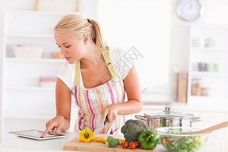 金发女人用平板电脑做饭图片