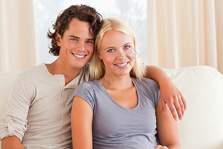 坐在沙发上的年轻夫妇金发女郎商业微笑生活成人电脑夫妻拥抱场景男人图片