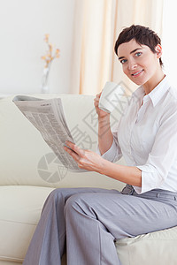 一个女人的肖像 一个用杯子看新闻 同时看着图片