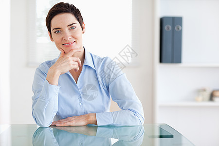 坐在办公桌后微笑的女商务人士图片