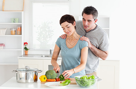 在他的妻子切菜时 在她施舍蔬菜的时候 让她的老婆做按摩图片