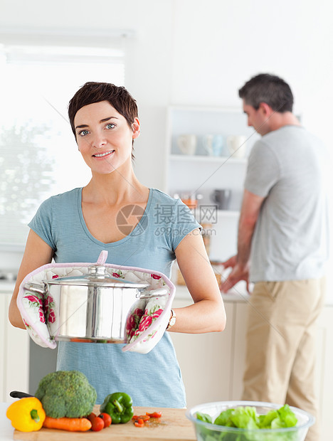 迷人的老婆拿着锅子 而丈夫在洗衣图片