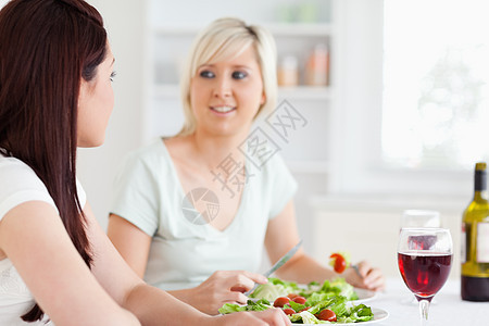 快乐女人吃沙拉的肖像厨房房子乐趣饮食蔬菜女性饮料瓶子午餐食物图片