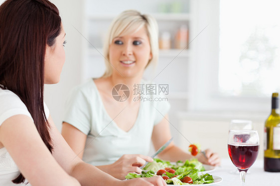 快乐女人吃沙拉的肖像厨房房子乐趣饮食蔬菜女性饮料瓶子午餐食物图片