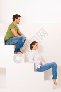 坐在台阶上的一对夫妇两人异性恋牛仔裤夫妻休闲装成年人异性男人女士日常生活图片