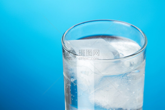 蓝色背景的冰水杯口渴玻璃立方体液体餐具反射白色水晶图片