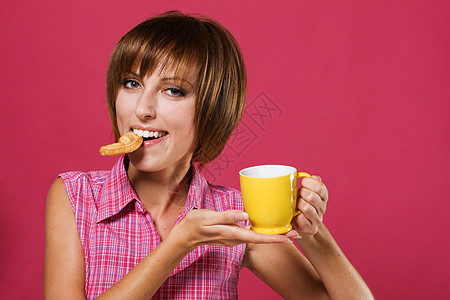 有饼干和茶杯的可爱女孩牛奶享受快乐早餐食物杯子女性糖果营养午餐图片