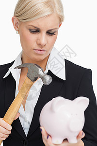 银行人员拿着锤子和小猪银行的可悲女商务人士背景