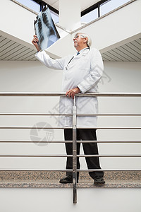 医生在看X射线时对栏杆倾斜图片