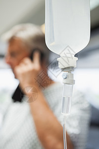 在背景情况下 与病人通电话的静脉滴灌图片