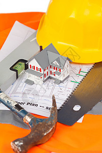橙色夹克上的工具和微型房屋红色工业房子金属头盔职业玩具工程师黄色橙子图片