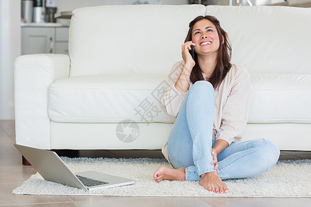 在电话里微笑的女人长椅棕色沙发住所社区键盘电脑手机家庭公寓图片