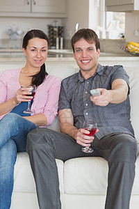 情侣在沙发上放松妻子享受男人男朋友房子玻璃电视长椅休息室红色图片