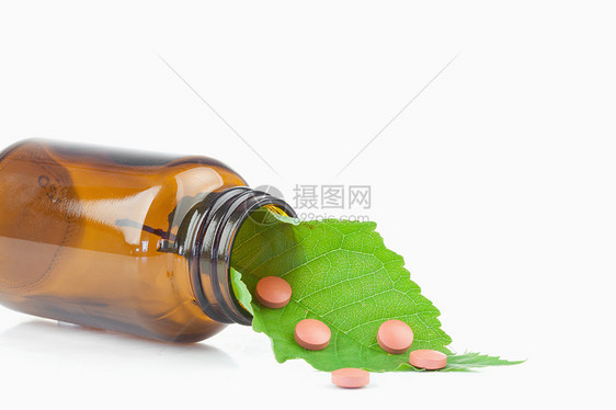 小瓶子里的叶子和药片草本植物医疗药品热带玻璃宏观白色温泉草本植物图片