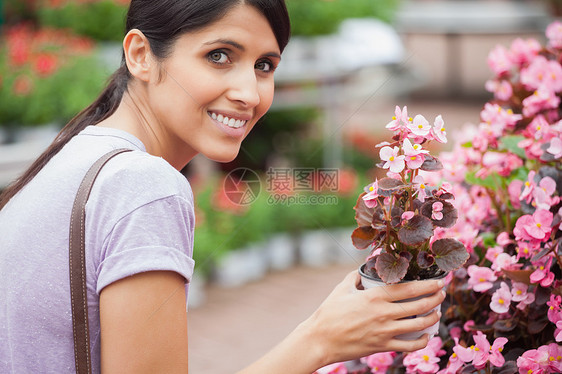 女人笑着拿着花朵快乐顾客植物头发幸福零售购物女士区系花园图片