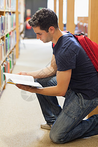 学生跪在书架上看书图片