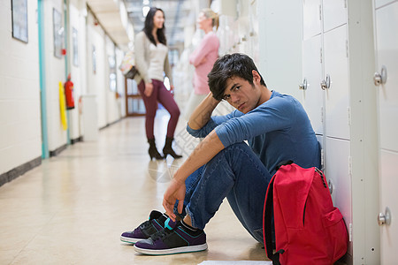 坐在地板上的男人大厅红色大学倾斜门厅教育混血微笑女性走廊图片