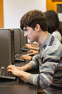 坐在计算机服务台打字的男子图片