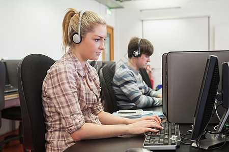 学生在计算机班上工作时佩戴耳机图片
