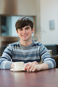 坐在桌子上的人 在大学咖啡厅喝咖啡图片