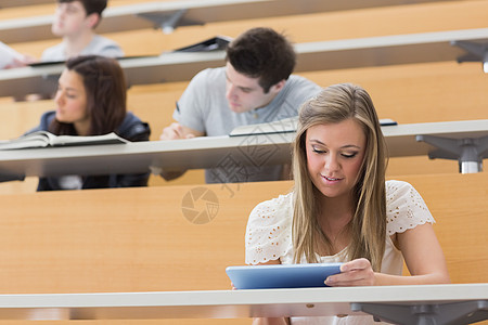 学生们坐在教室里 拿着平板电脑背景图片