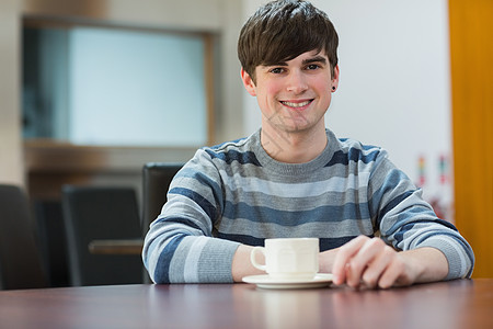 在大学咖啡厅喝咖啡的学生坐在桌边上图片