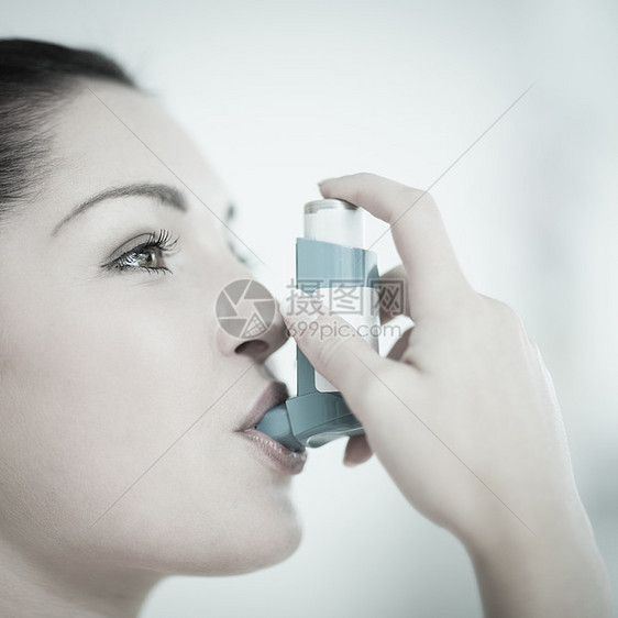 患有哮喘的妇女使用吸入器图片