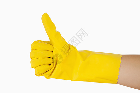 女人用黄色手套的手举起拇指背景图片