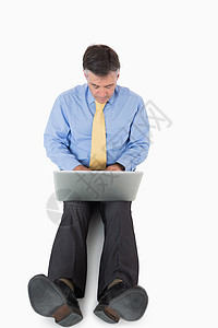 坐在地板上做笔记本电脑工作的商务人士夹克生意人领带技术套装头发衬衫管理人员地面男性图片