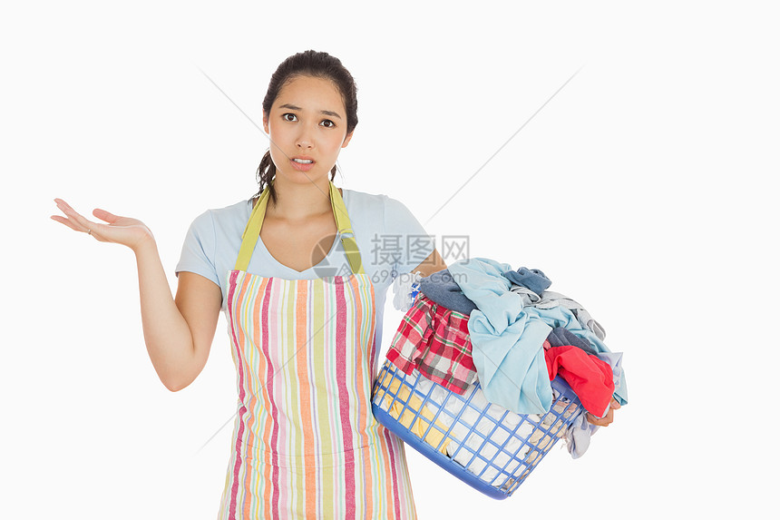 拿着满满是脏衣服的洗衣篮的被骗的年轻女子图片