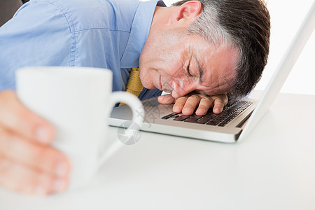 男人一边喝咖啡一边睡在笔记本电脑上杯子技术男性午睡头发套装衬衫睡眠桌子领带图片