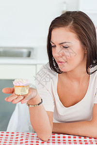 棕褐色美女在看纸杯蛋糕图片