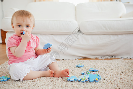 坐在地毯上玩拼图游戏的可爱婴儿 坐到地毯上图片