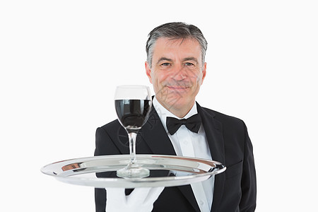 在银盘上拿着一杯酒的笑脸服务员套装衬衫男性服务玻璃奢华白色领结图片
