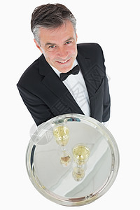 端着香槟银盘的服务员奢华嘶嘶头发玻璃男性起泡手套衣冠服务套装图片