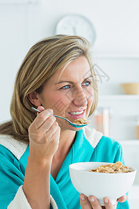妇女食谷类食品女性浅色谷物长发勺子金发厨房微笑女士早餐图片