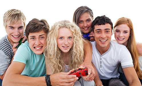 兴奋的青少年在客厅里玩电子游戏享受游戏技术女士朋友们电脑微笑控制器白色男性图片