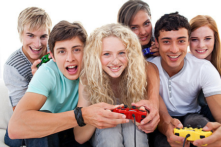 青少年在客厅玩电子游戏的肖像男性乐趣视频男人朋友们微笑电脑控制器女士女性图片