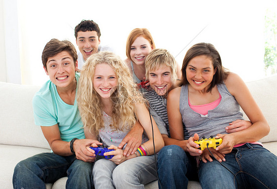 在客厅玩电子游戏的友人游戏女士女性娱乐白色微笑乐趣视频朋友们男性图片