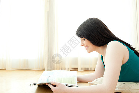 有兴趣看杂志的女人 躺在地板上阅读的杂志图片