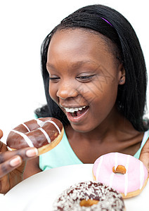 快乐的年轻女人 吃巧克力甜甜甜圈蛋糕甜点女士垃圾小吃咀嚼甜甜圈成人微笑饮食图片