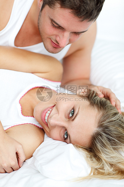 迷人的男人看着他的女孩 在床上被泡在床上图片