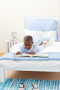 小男孩在看书快乐枕头说谎童年兴趣知识分子男生阅读儿子意义图片